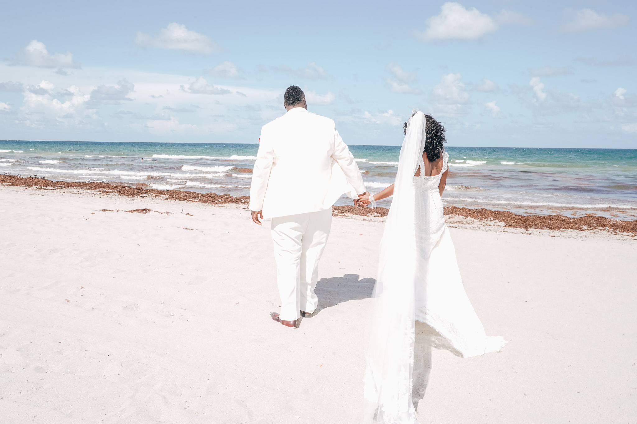 newlywed couple takes stroll after wedding on hollywood beach in florida