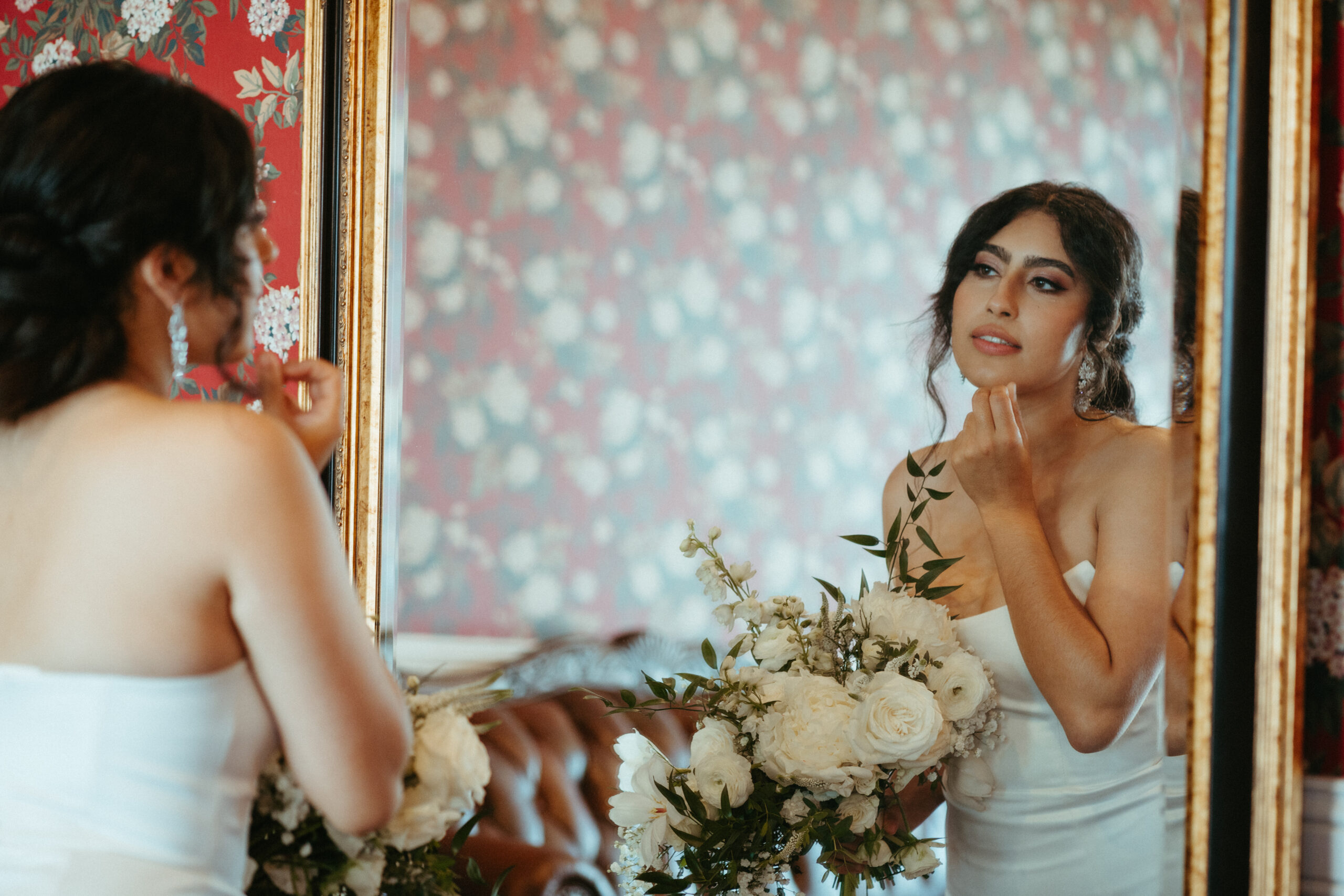 beautiful bride checks her makeup in mirror before walking down the aisle